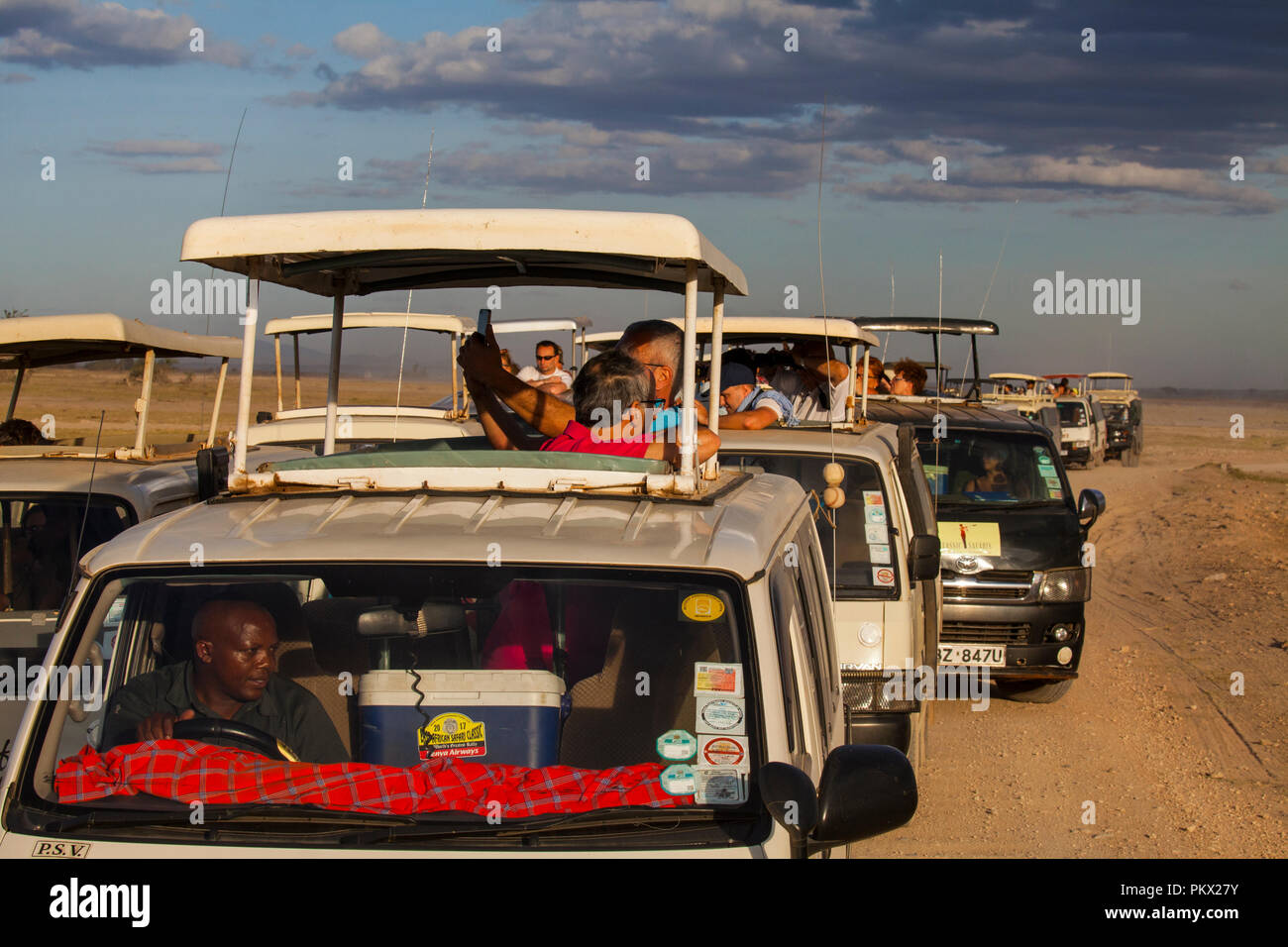 AMBOSELI NATIONAL PARK, KENYA - FEBRUARY 22, 2018: Traffic jam in Amboseli - the tourists watching the lions family from a safari car. Stock Photo