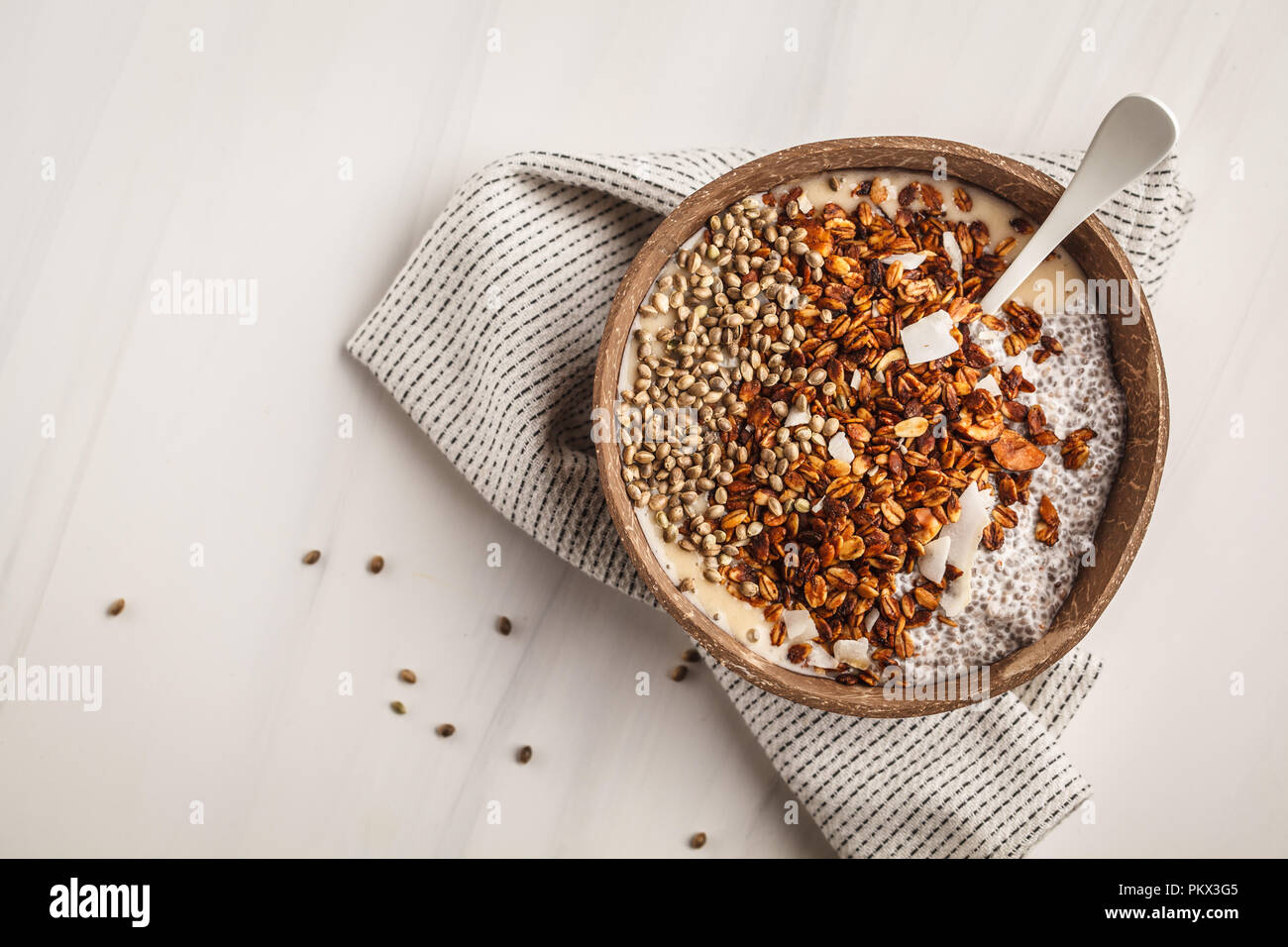 Smoothie bowl with granola, chia pudding and hemp seeds in coconut