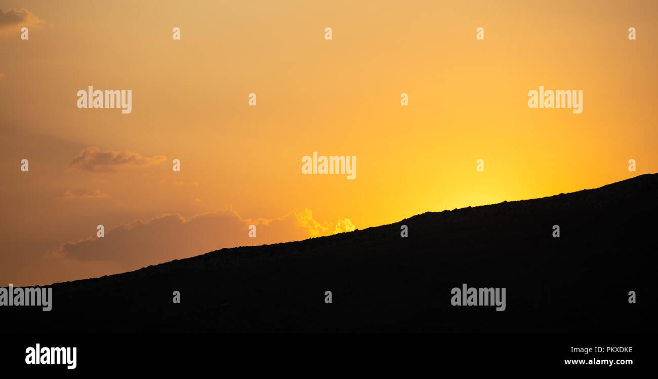 Sunset, sunrise over mountains silhouette. Scattered clouds on colorful sky background, space, banner. Stock Photo