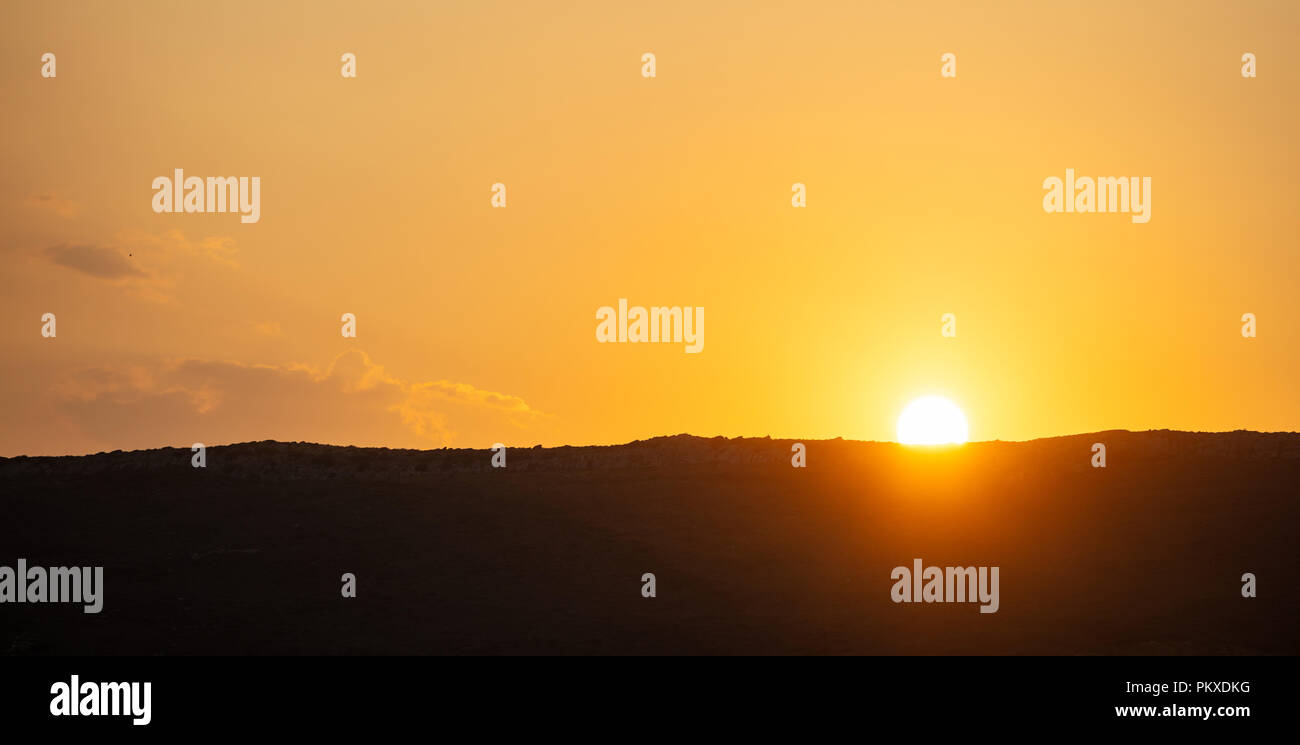 Sunset, sunrise over mountains silhouette. Scattered clouds on colorful sky background, space, banner. Stock Photo