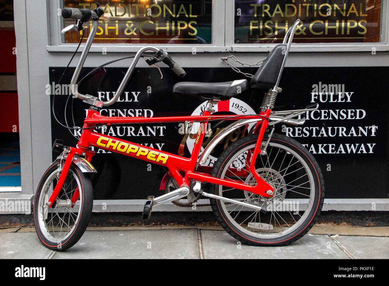 An immaculate Raleigh Chopper parked outside a fish and chip shop in London's Soho Stock Photo