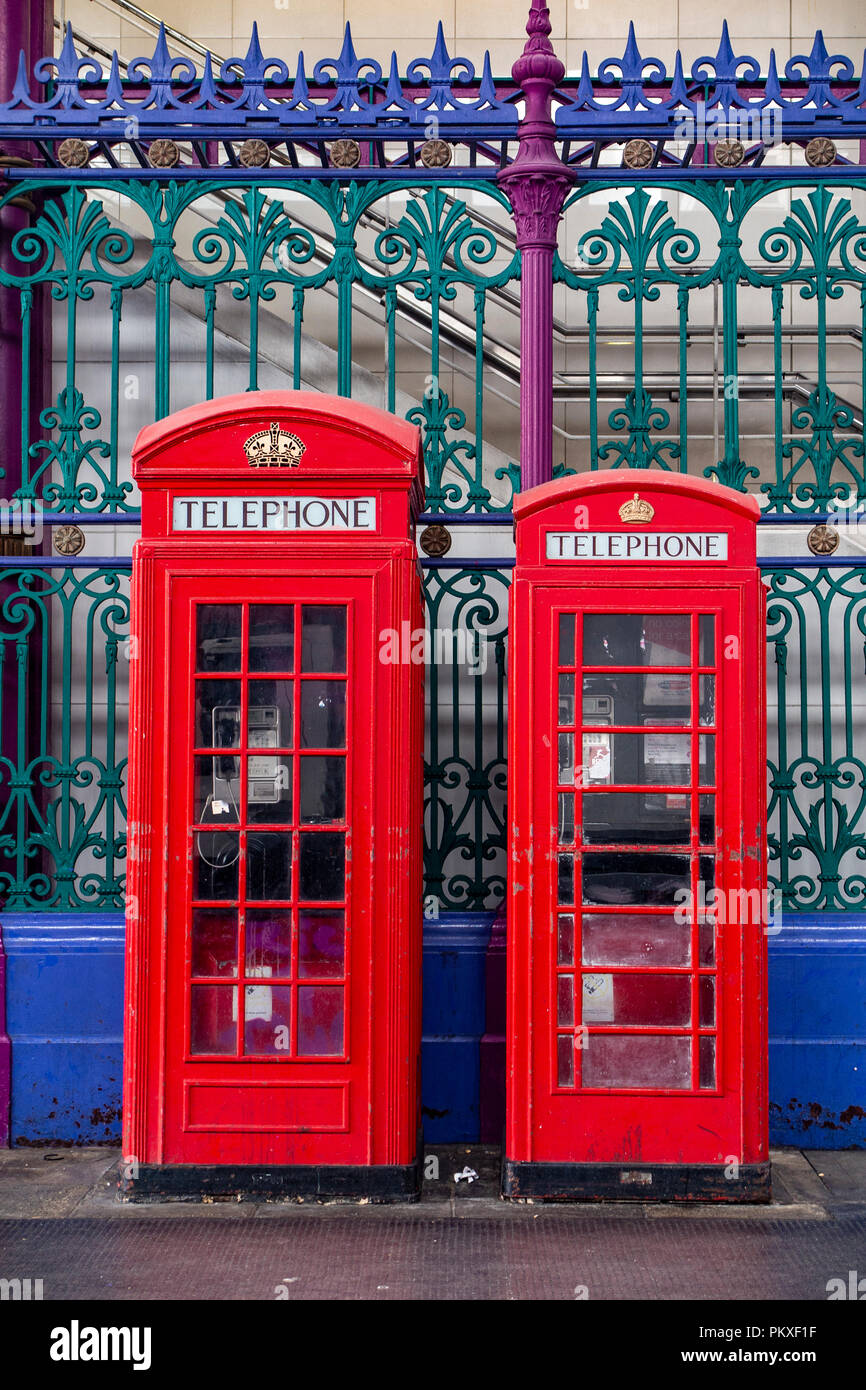 Iconic telephone boxes in an iconic location in the City of London with blurred passers by Stock Photo