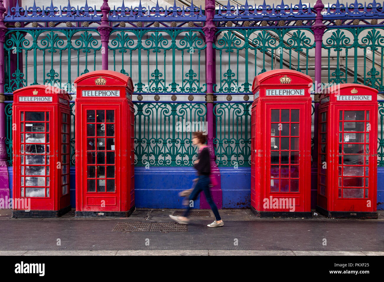 Iconic telephone boxes in an iconic location in the City of London with blurred passers by Stock Photo