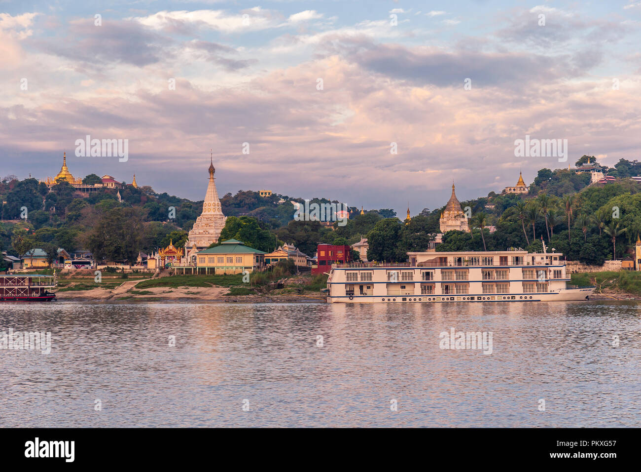 Pagodas gleam on the serene riverbanks of the Irrawaddy in Myanmar Stock Photo