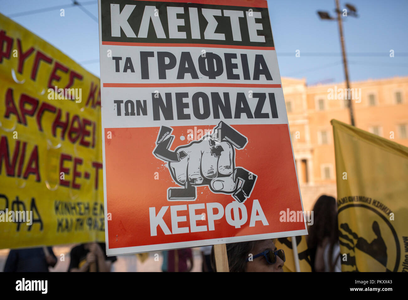 Athens, Greece. 15th Sep, 2018. A demonstrator holds a sign saying 'Close every neo-Nazi office' as a flag during a march against racism and fascism. Thousands of people commemorated the murder of a rapper by a neo-Nazi in the port city of Piraeus five years ago on Saturday evening in central Athens and in other Greek cities. Credit: Socrates Baltagiannis/dpa/Alamy Live News Stock Photo