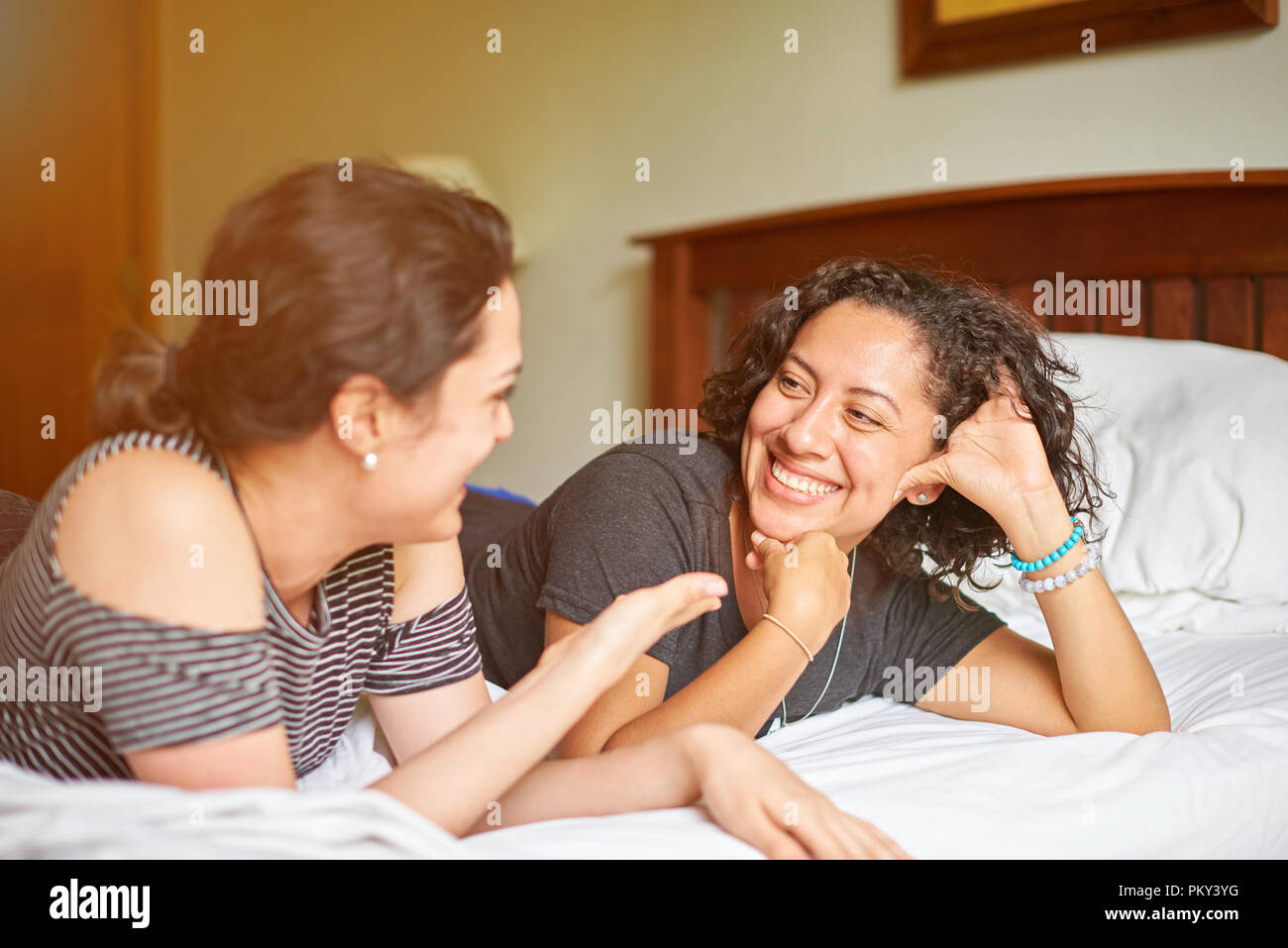 Two young woman talk on bed. Friendship of girls concept Stock Photo
