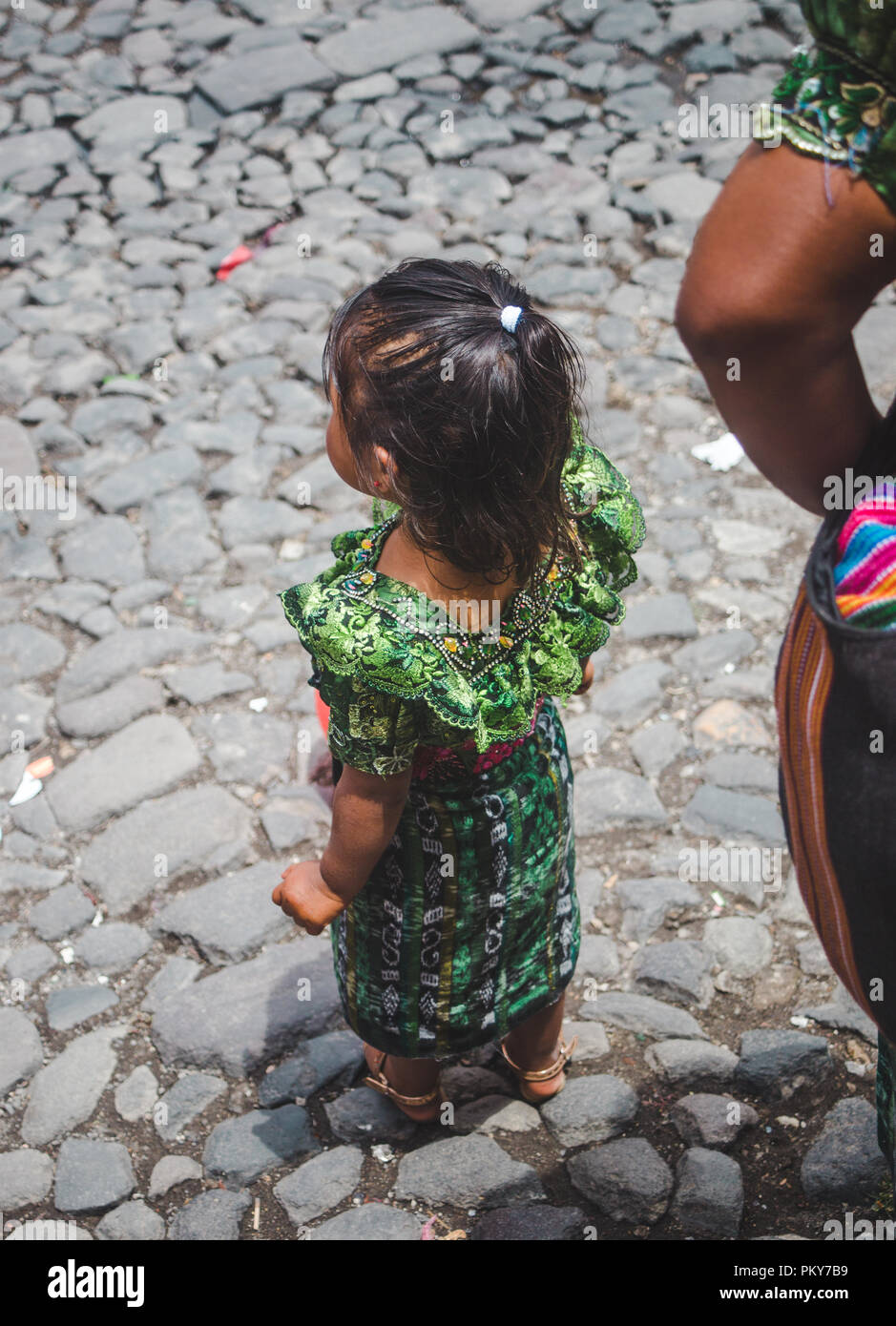 Small girl in traditional Mayan traje dress watched street parade in wonder on Dia de la Independencia 2018 (Independence Day) in Antigua Guatemala Stock Photo