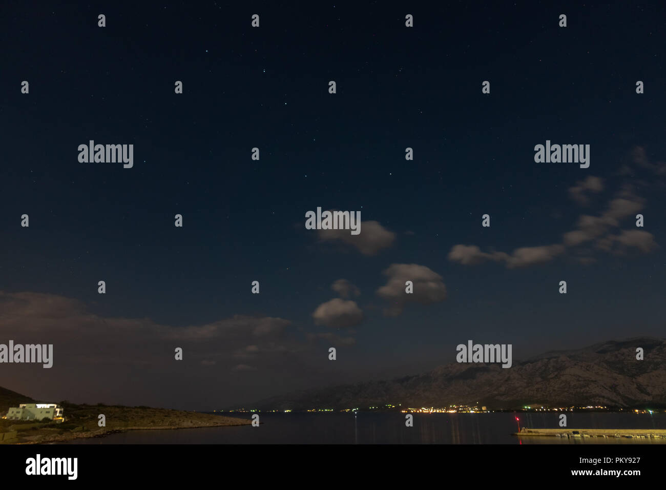 Seascape under stars, ursa major, mountains in background Stock Photo