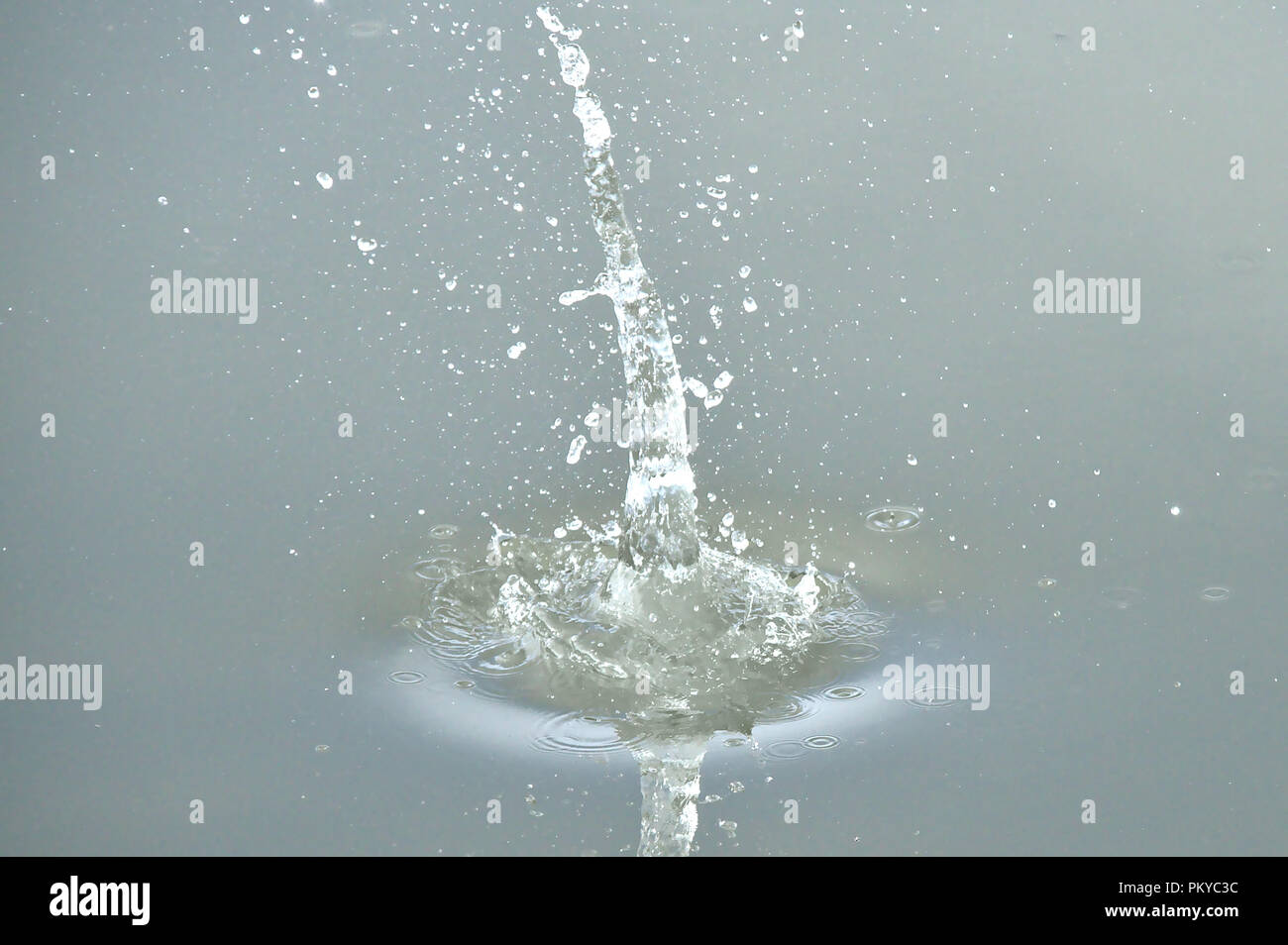 Splash from small stone dropped into the water. Stock Photo