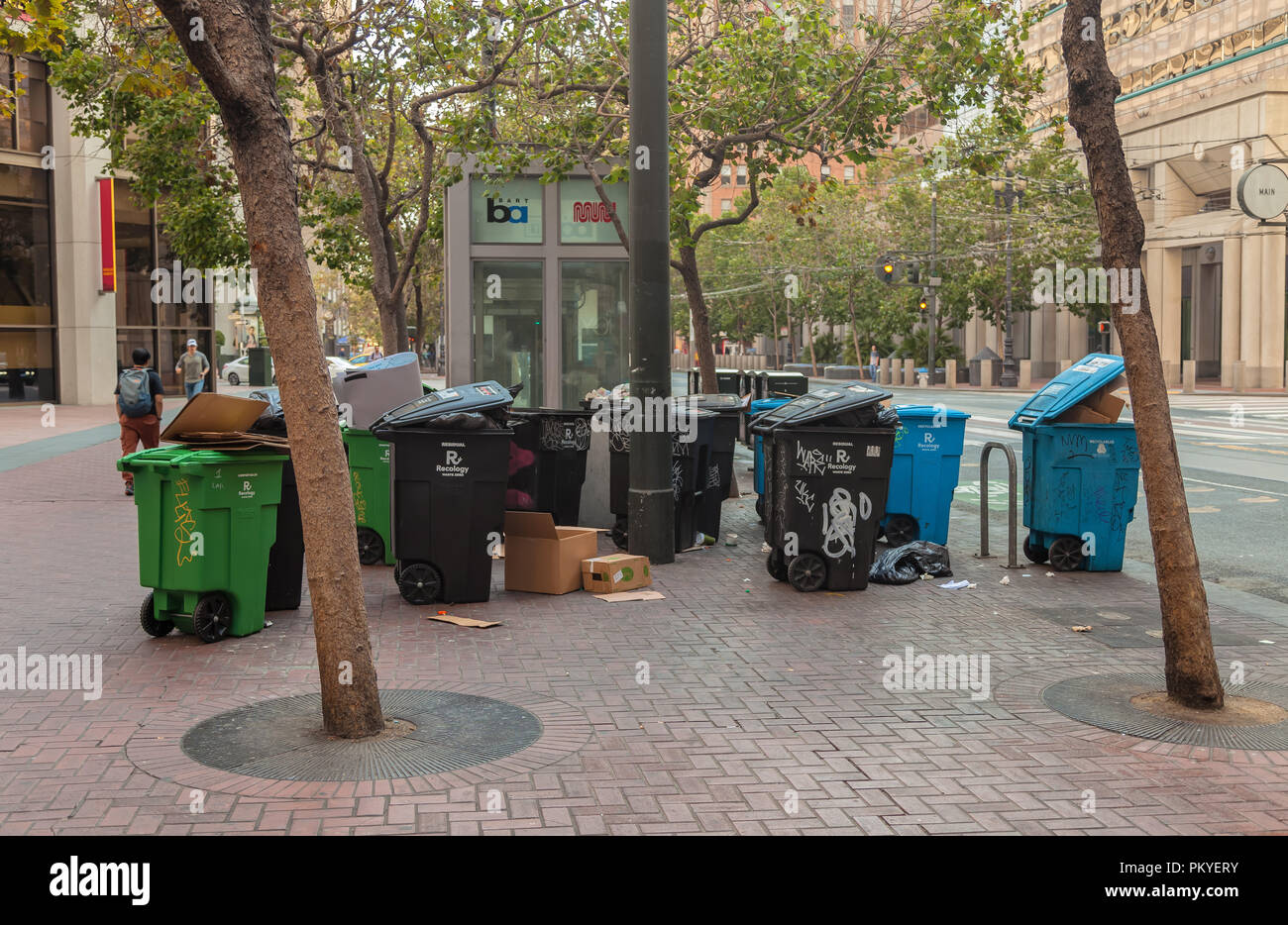 Trash and recycle can on the sidewalk are ready to be picked up in