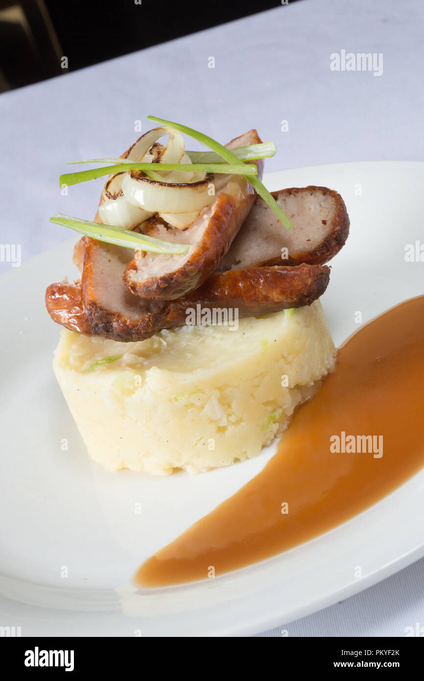 An English pub/restaurant dish of Sausage and mash potato with rich brown gravy. Stock Photo