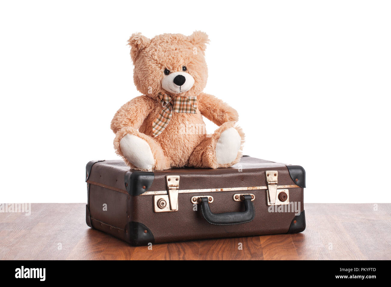 Old teddybear sitting on vintage suitcase. Stock Photo
