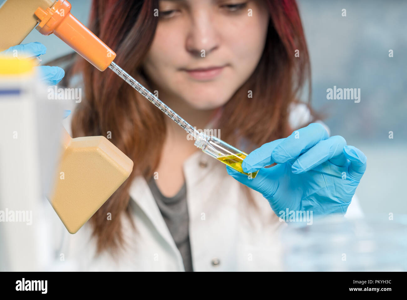 pretty female laboratory assistant analyzing a biological sample at