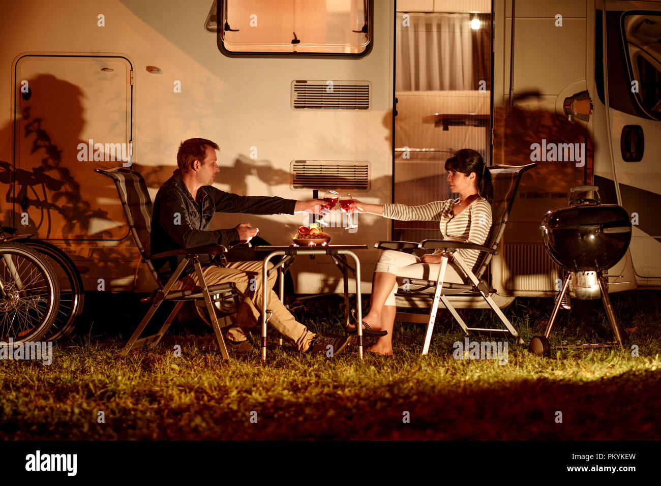 Adult couple clinking glasses of wine. Family vacation travel RV