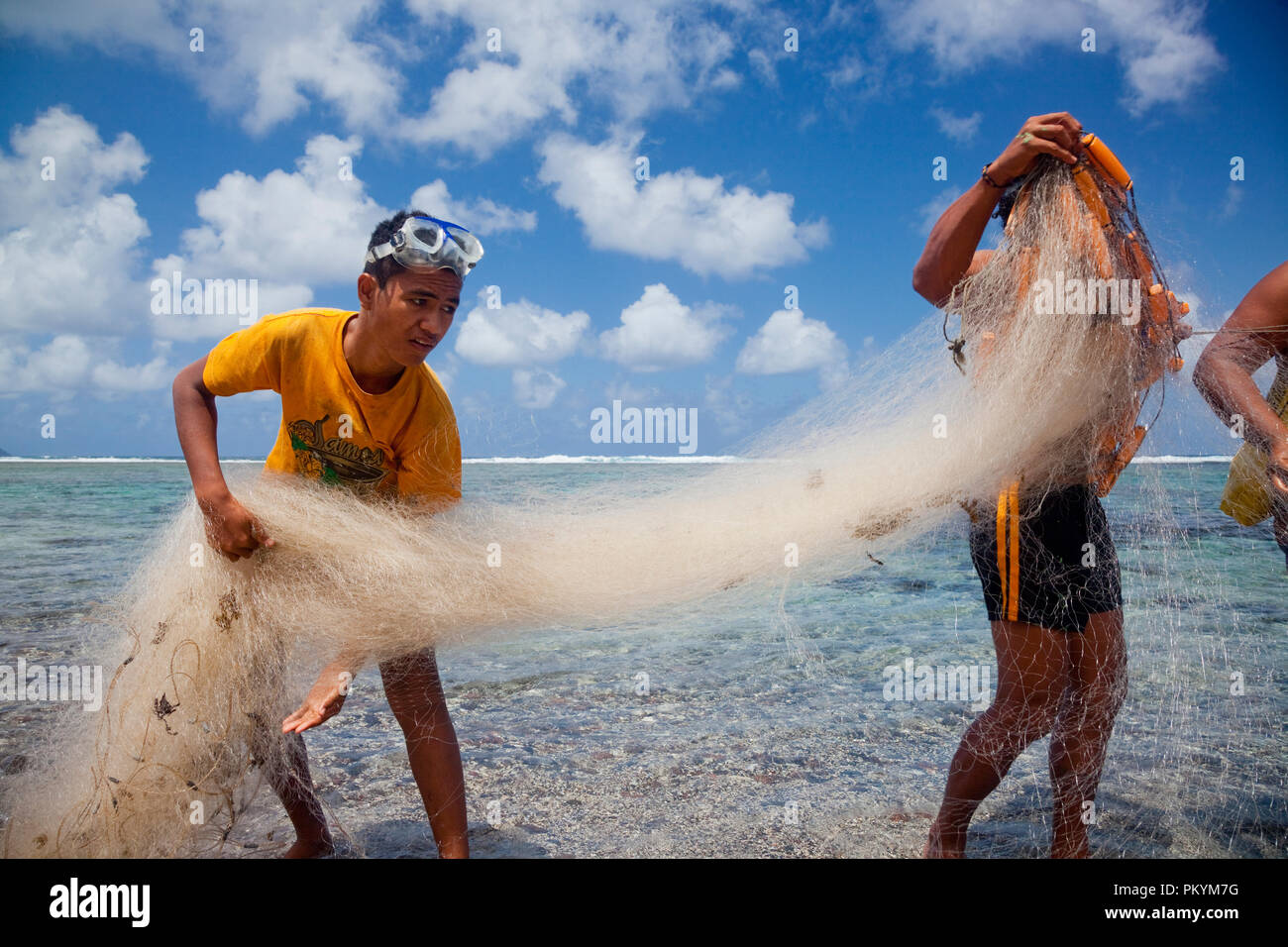 Locals prepare a fishing net to catch fish in the lagoon at Lepa Beach, Samoa. Stock Photo