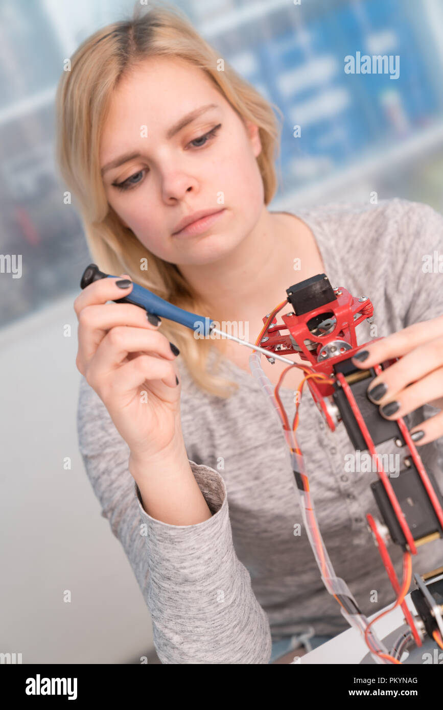 Young attractive female engineer working on robotics project Stock Photo