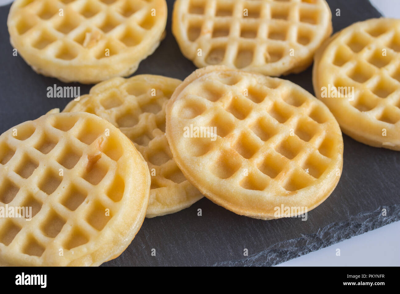 Heap Of Round Small Waffles On Wooden Table Stock Photo, Picture and  Royalty Free Image. Image 109220711.