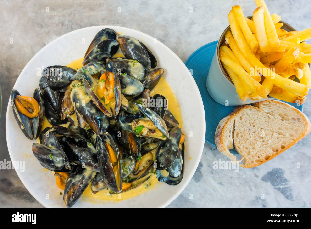 Moules Mariniere served with thin Chips and Sourdough bread lunchtime meal at the Seaview Café Saltburn North Yorkshire UK Stock Photo