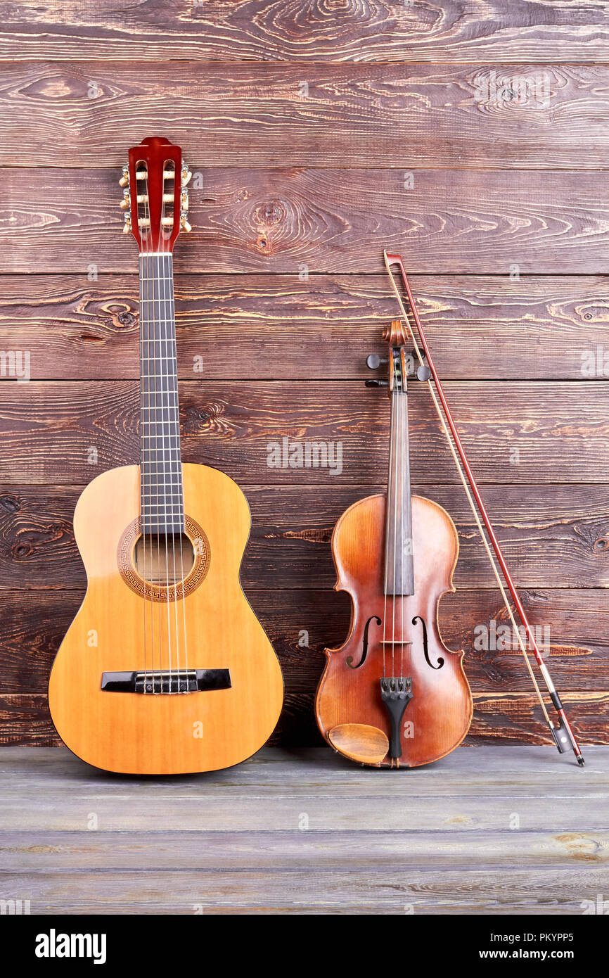 Guitar and violin on wooden background. Vintage style musical instruments  on wooden surface, vertical image. Music still life Stock Photo - Alamy