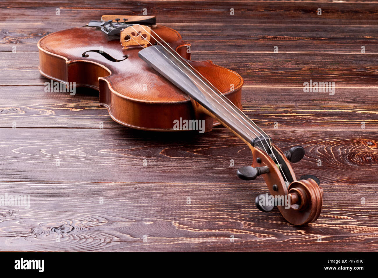 Violin on brown wooden background. Stock Photo