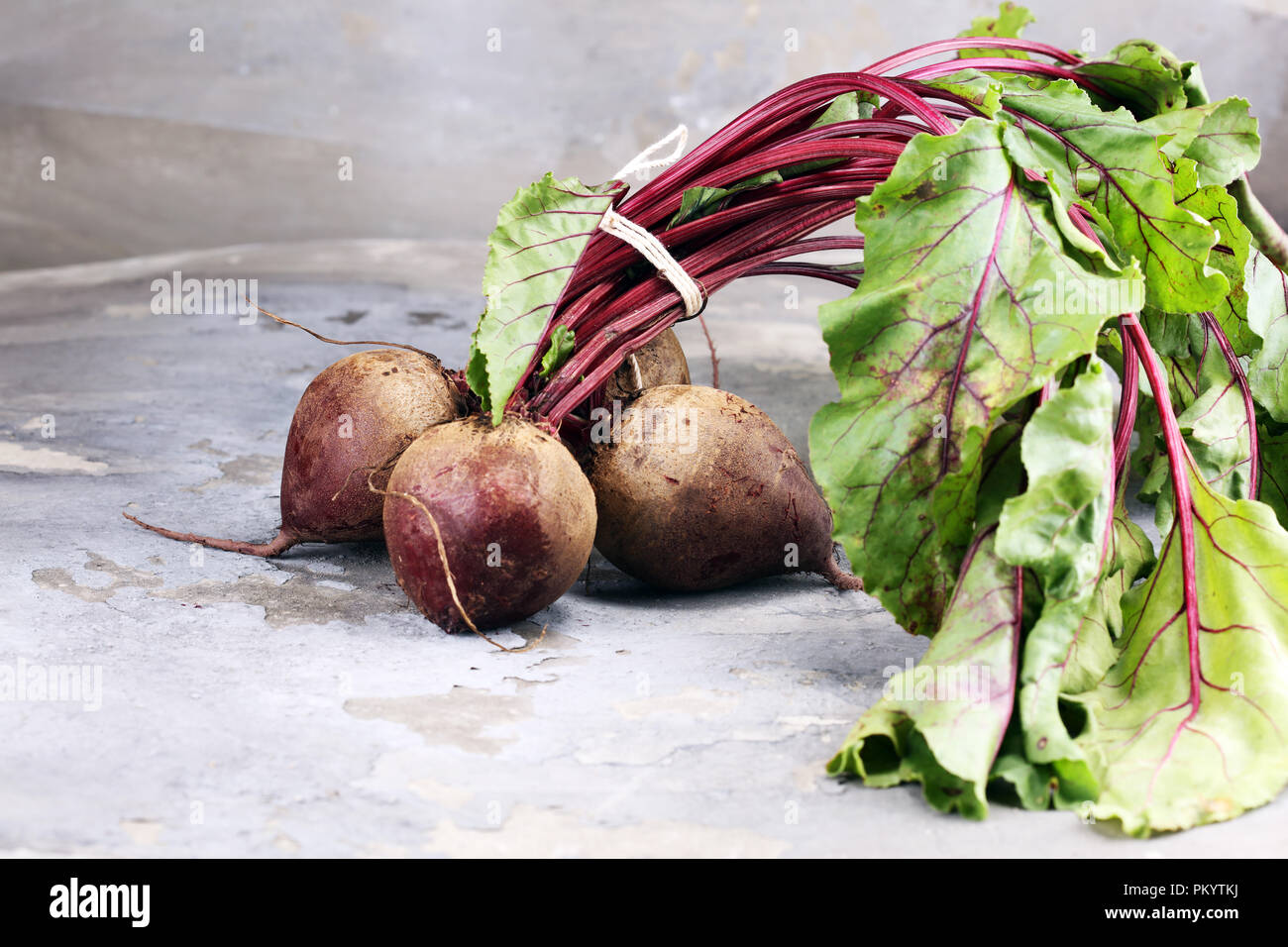 Red Beetroot with herbage green leaves on rustic background. Organic Beetroot. Stock Photo