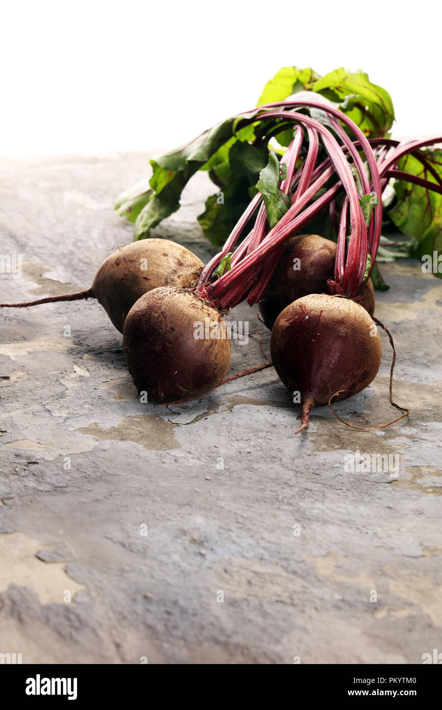 Red Beetroot with herbage green leaves on rustic background. Organic Beetroot. Stock Photo