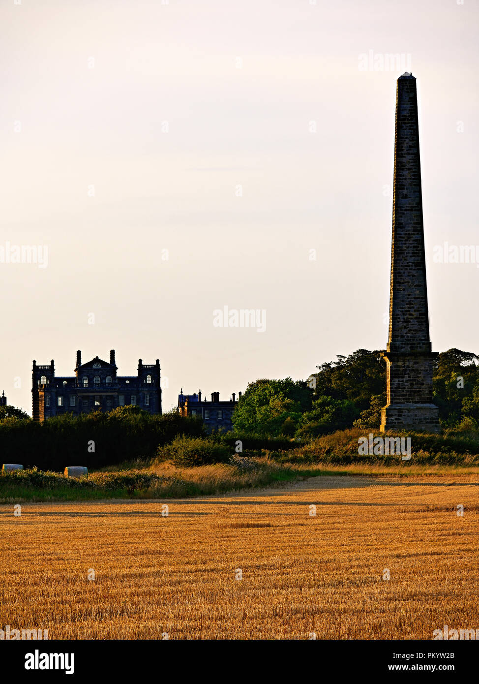Seaton Deleval Hall and obelisk in corn fields at sunset Stock Photo