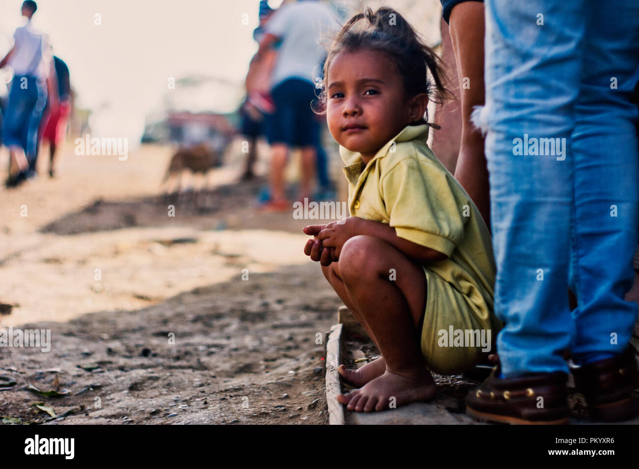 BARCELONA, VENEZUELA June 2, 2018: girl in the poor community 'ciudad de los mochos' sitting barefoot in the street Stock Photo
