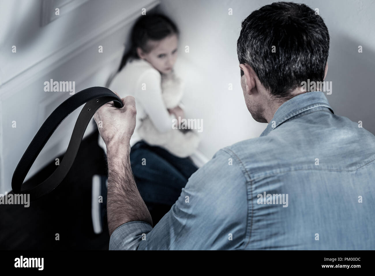 Small child sitting in a corner Stock Photo Alamy