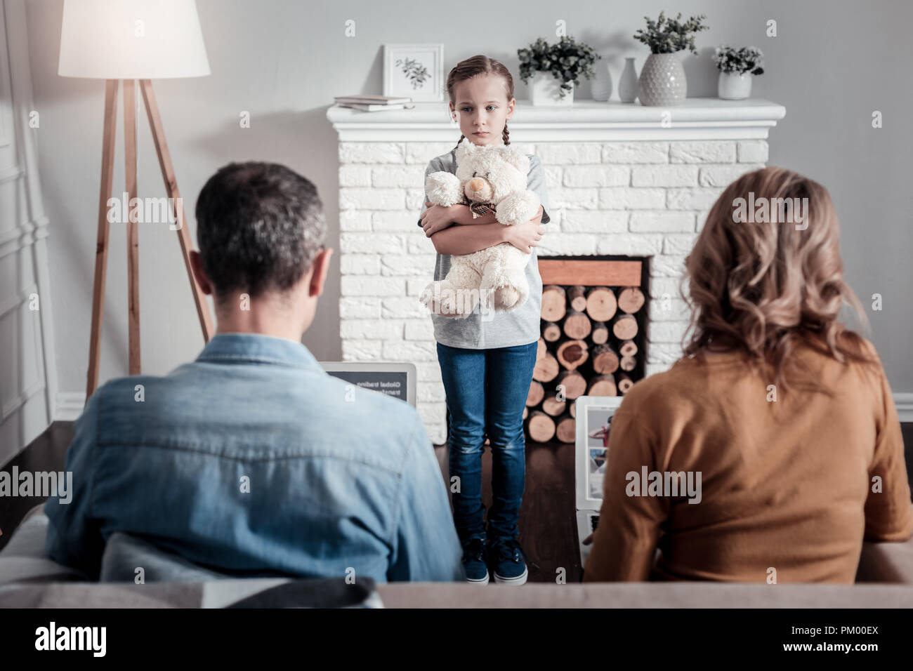Lonely child standing in the middle of a room Stock Photo