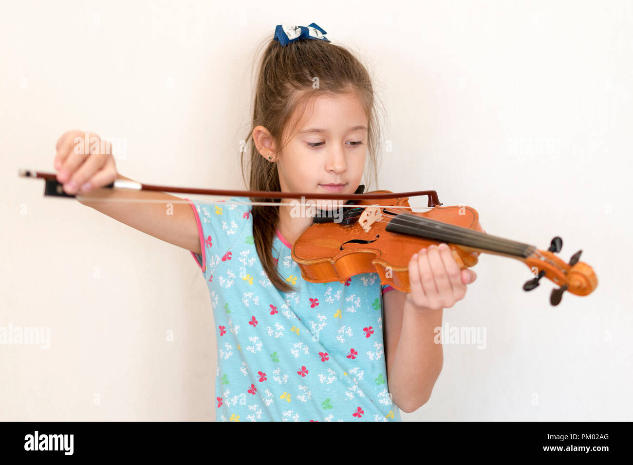 Cute pupil playing violin in classroom at the elementary school. Girl ...