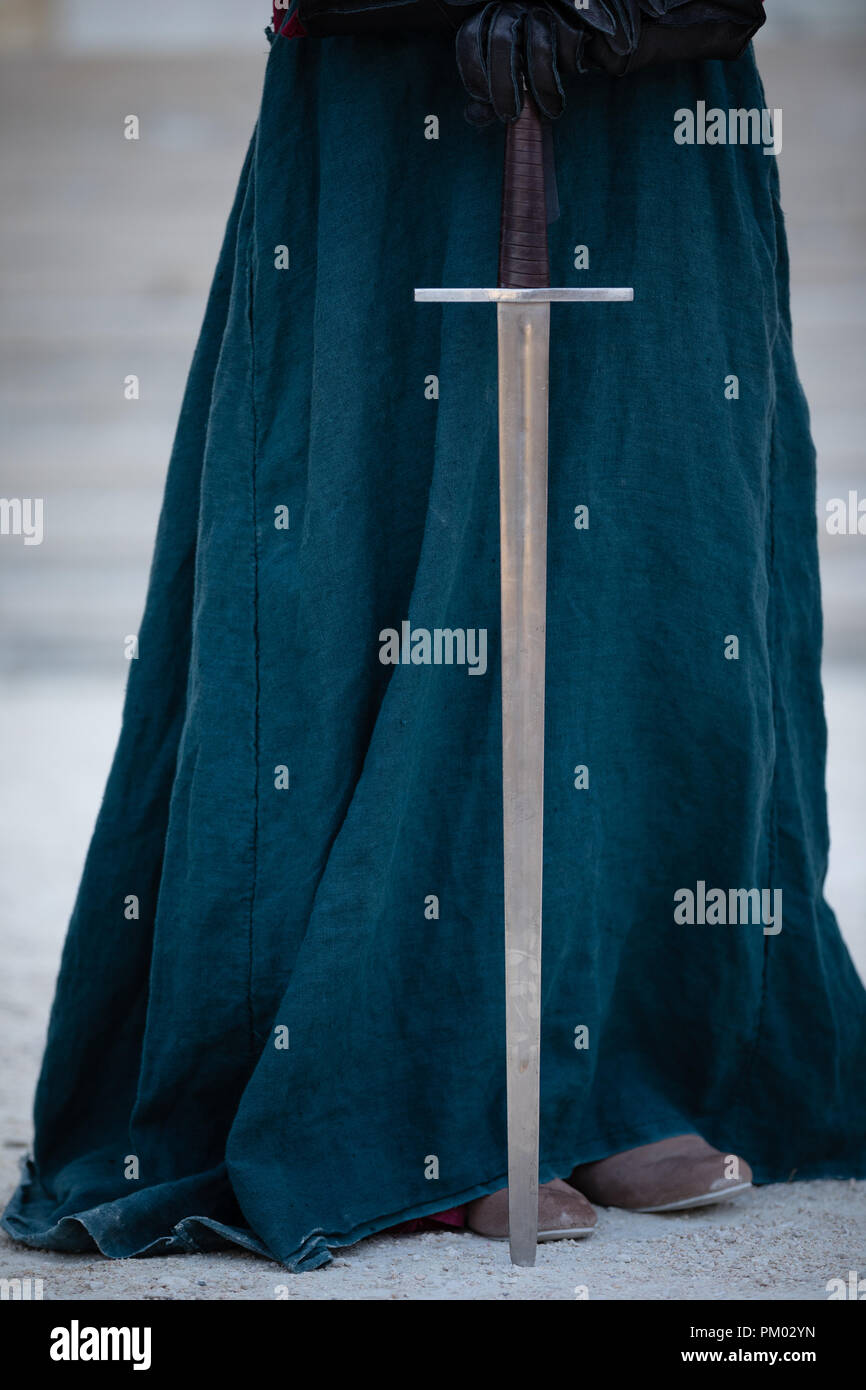 Blue green dress with sword and leather gloves. Stock Photo