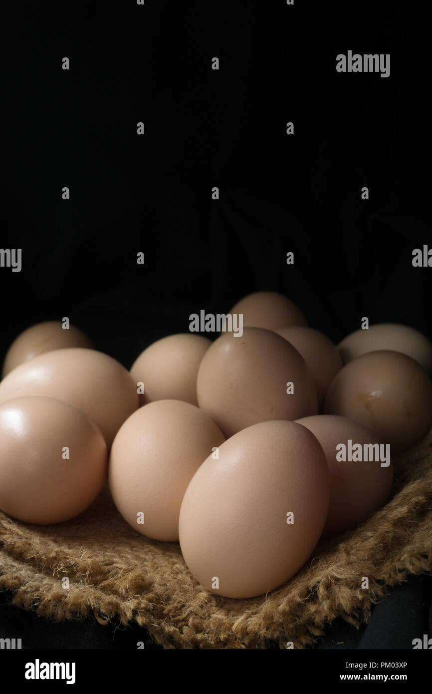 Eggs in a nest on hemp sack, dark corner. Stock Photo