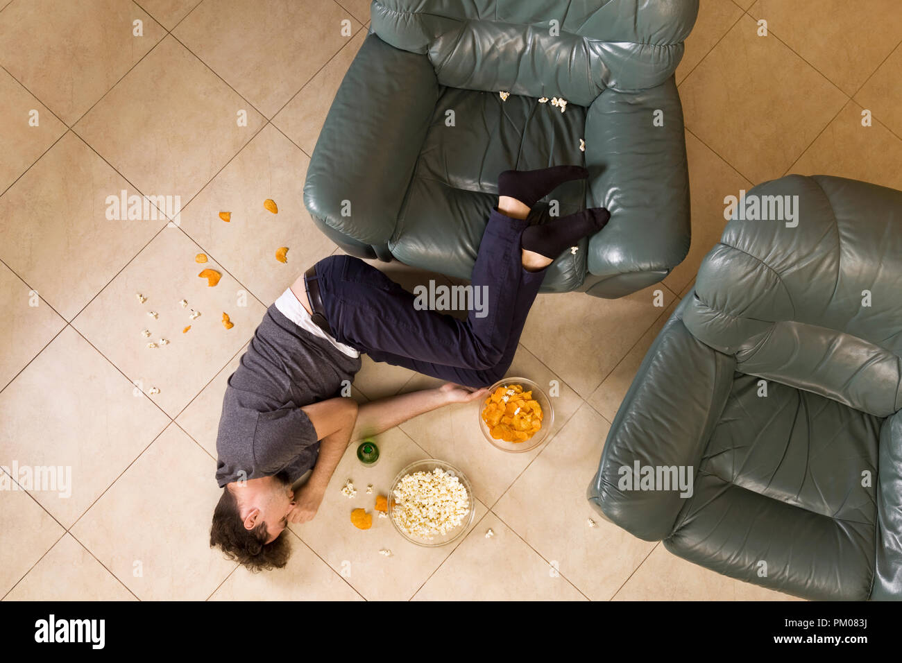 Top view of guy sleeping in messy room after having a party at home Stock Photo