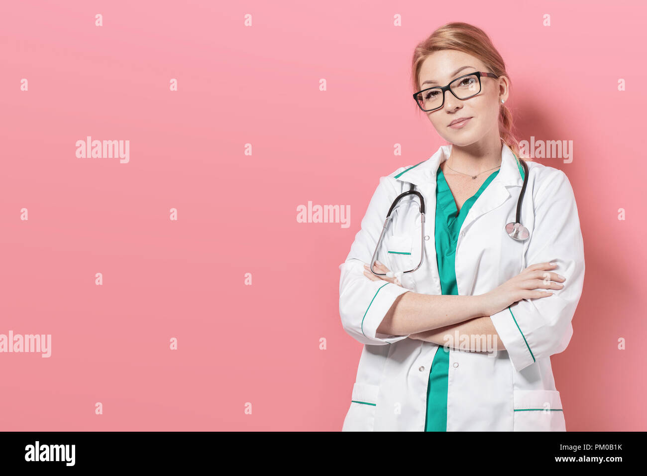 Woman in doctor uniform stands over pink background. Photo with ...