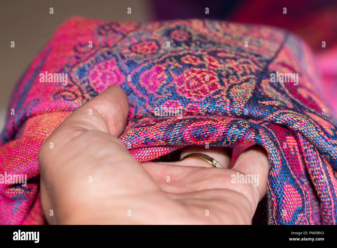 Hand holding a pink and purple original cashmere scarf Stock Photo