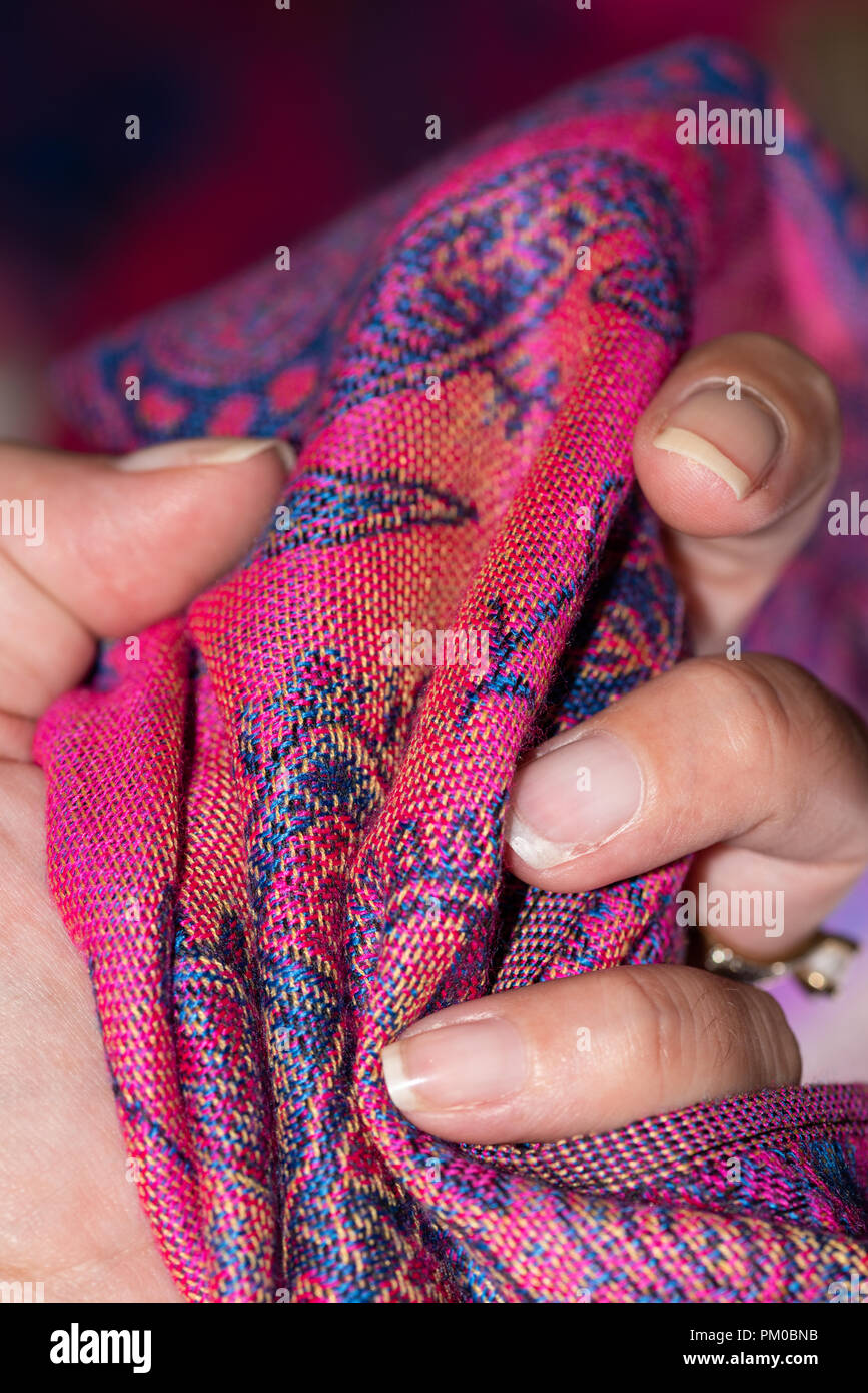 Hand holding tight a pink and purple original cashmere scarf Stock Photo