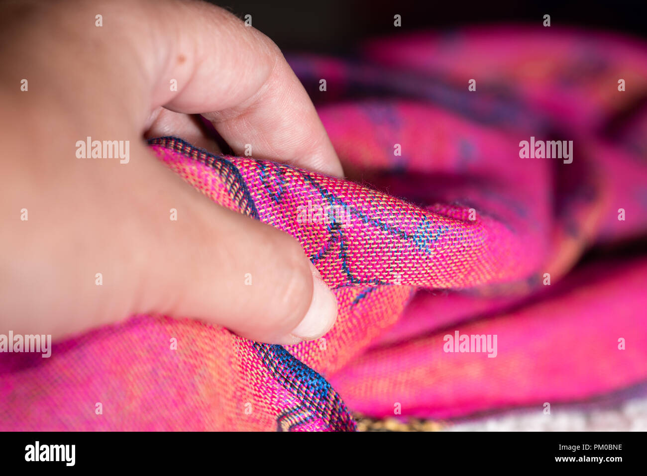 Hand soflty touching a pink cashmere fabric Stock Photo