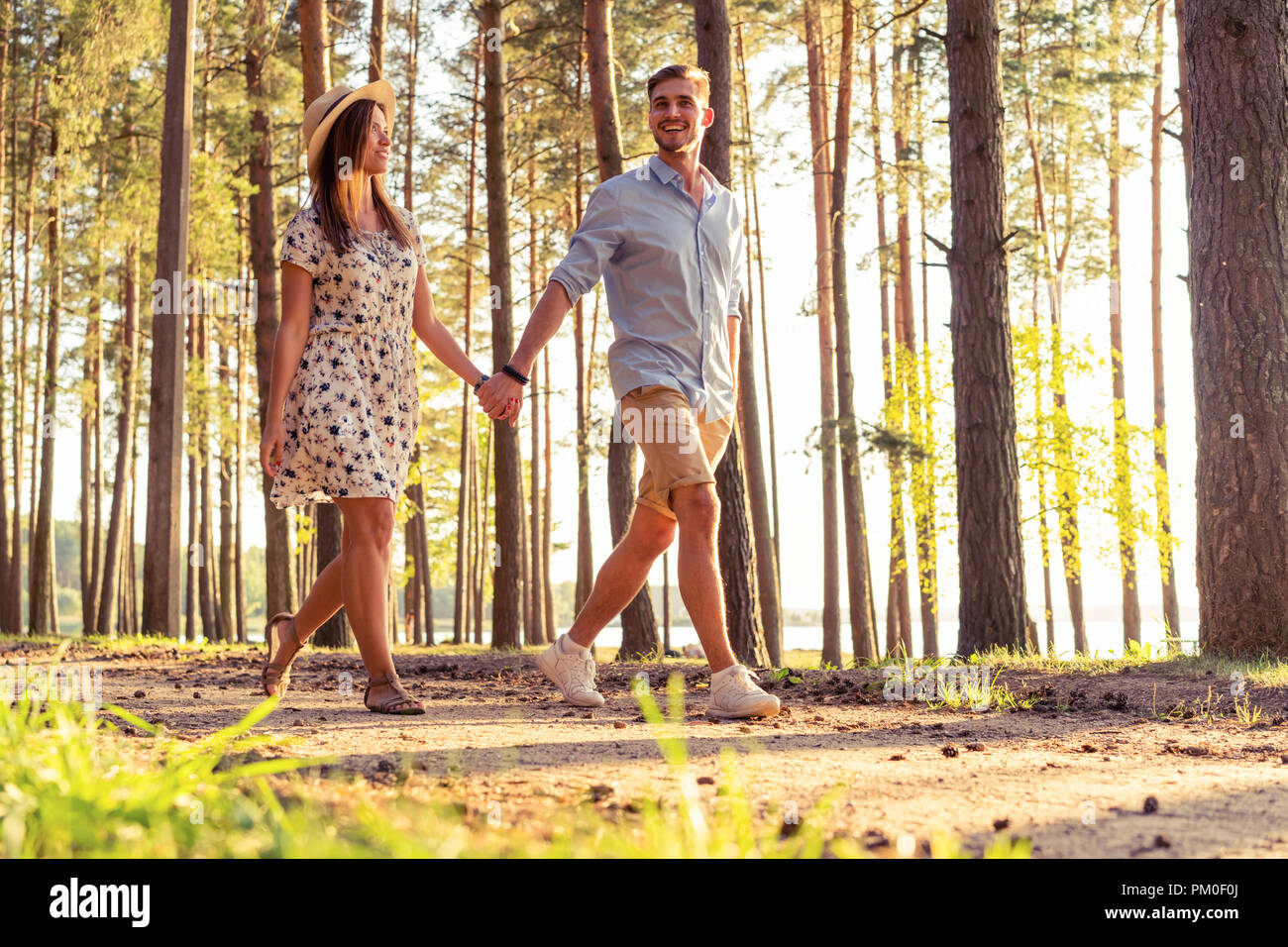 Young couple in love walking in the autumn park holding hands looking ...