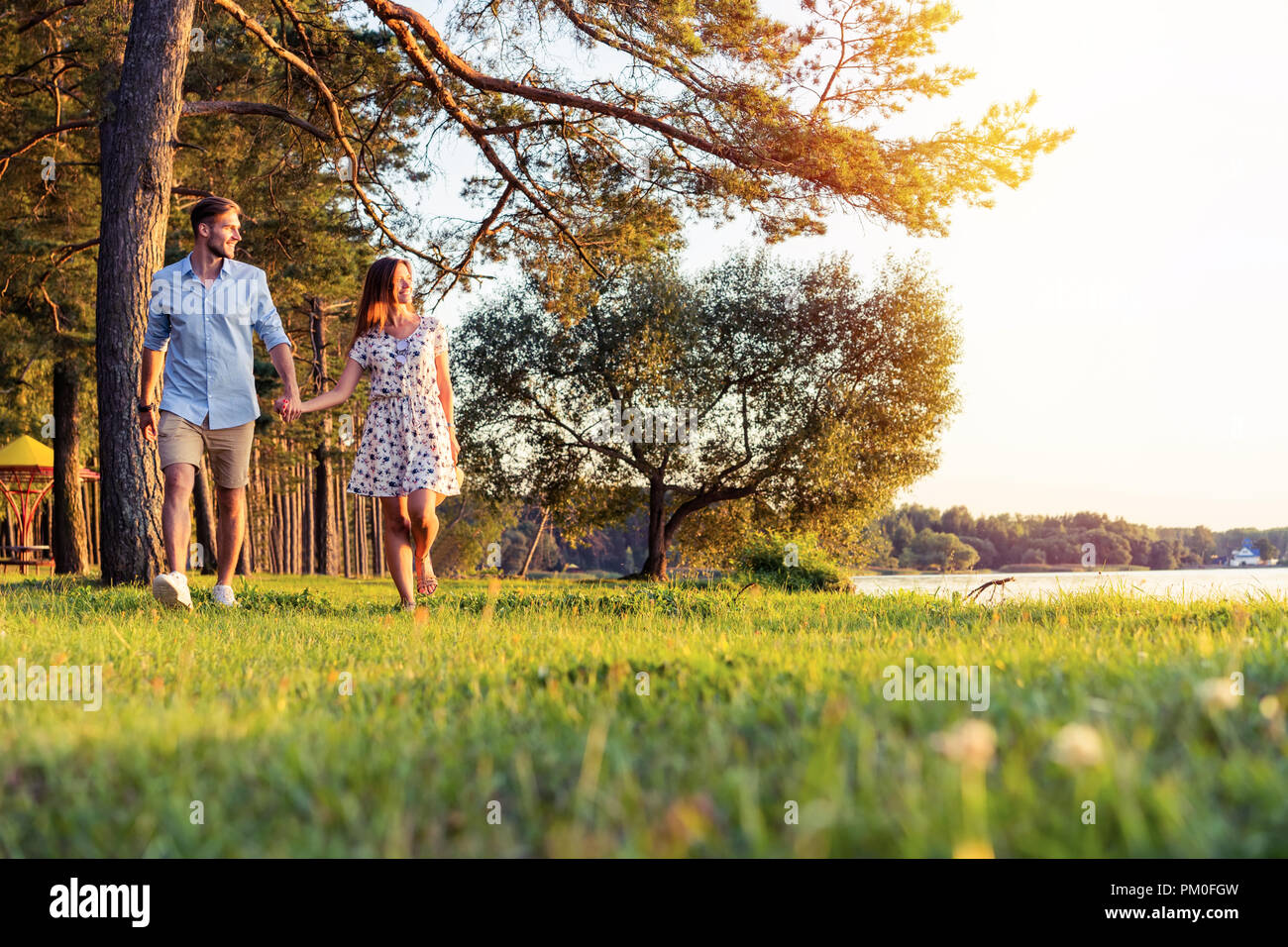 Young couple in love walking in the autumn park holding hands looking ...