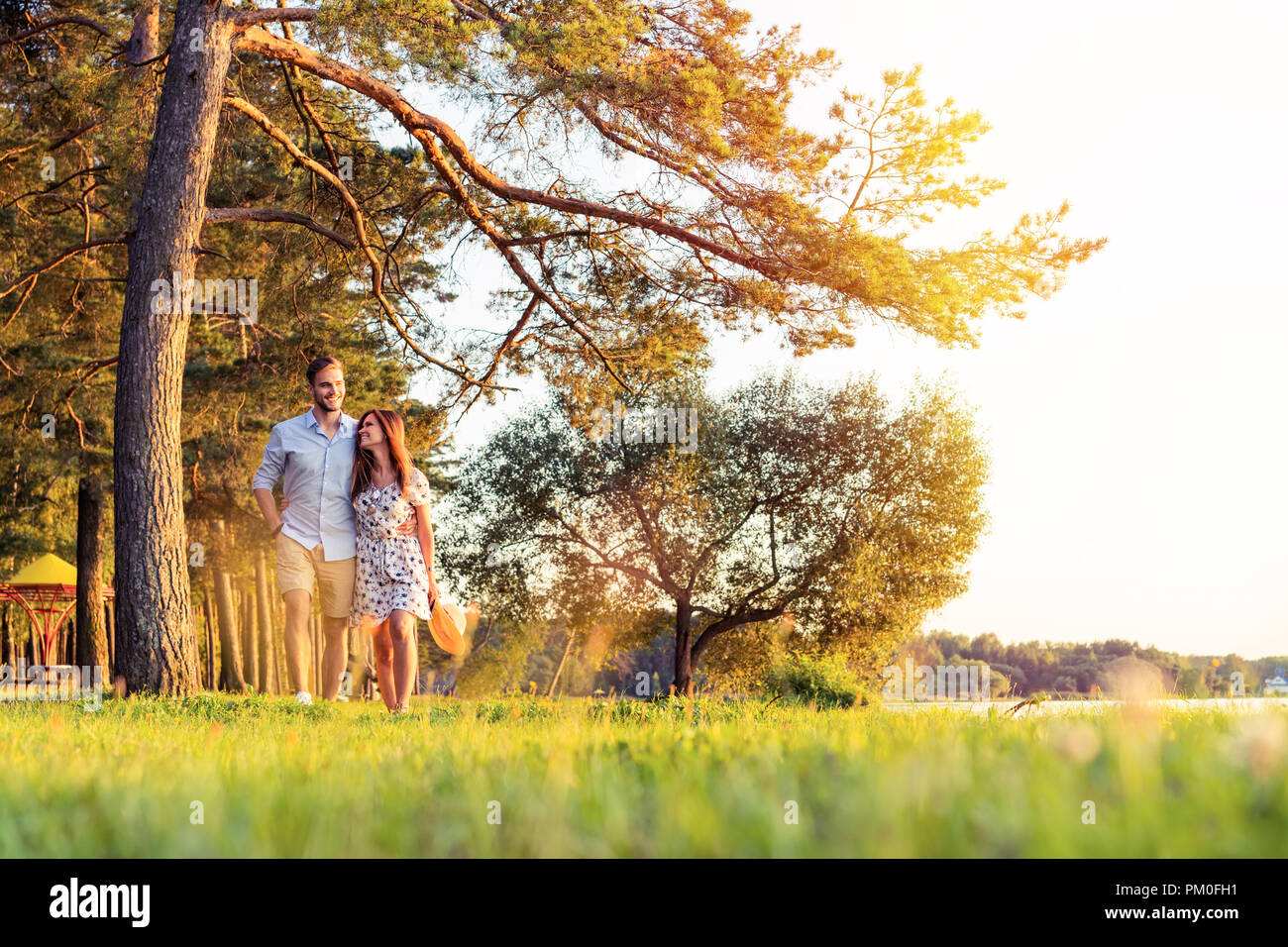 Young couple in love walking in the autumn park holding hands looking ...