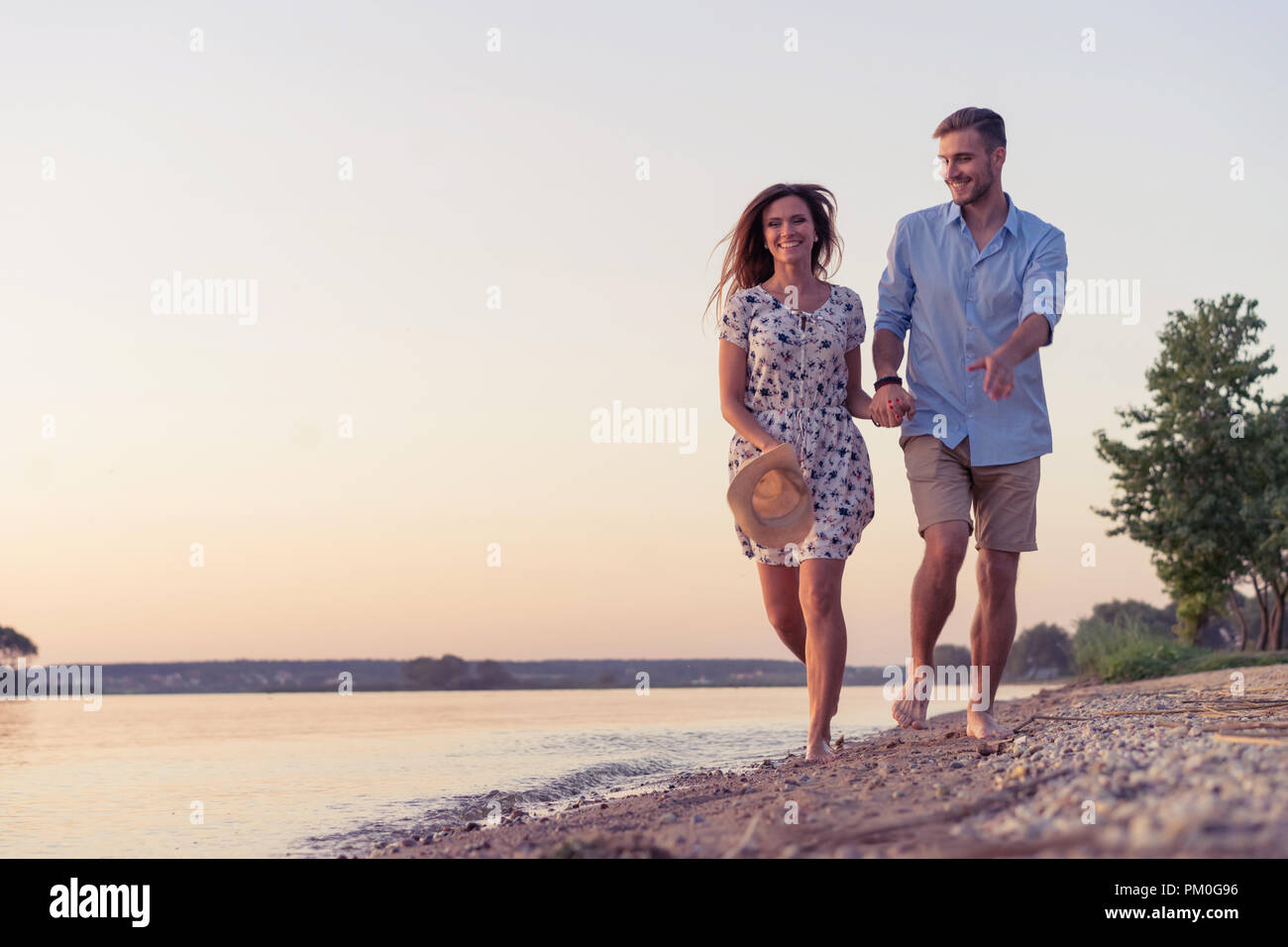 Couple walking on the beach at sunset Stock Photo Alamy