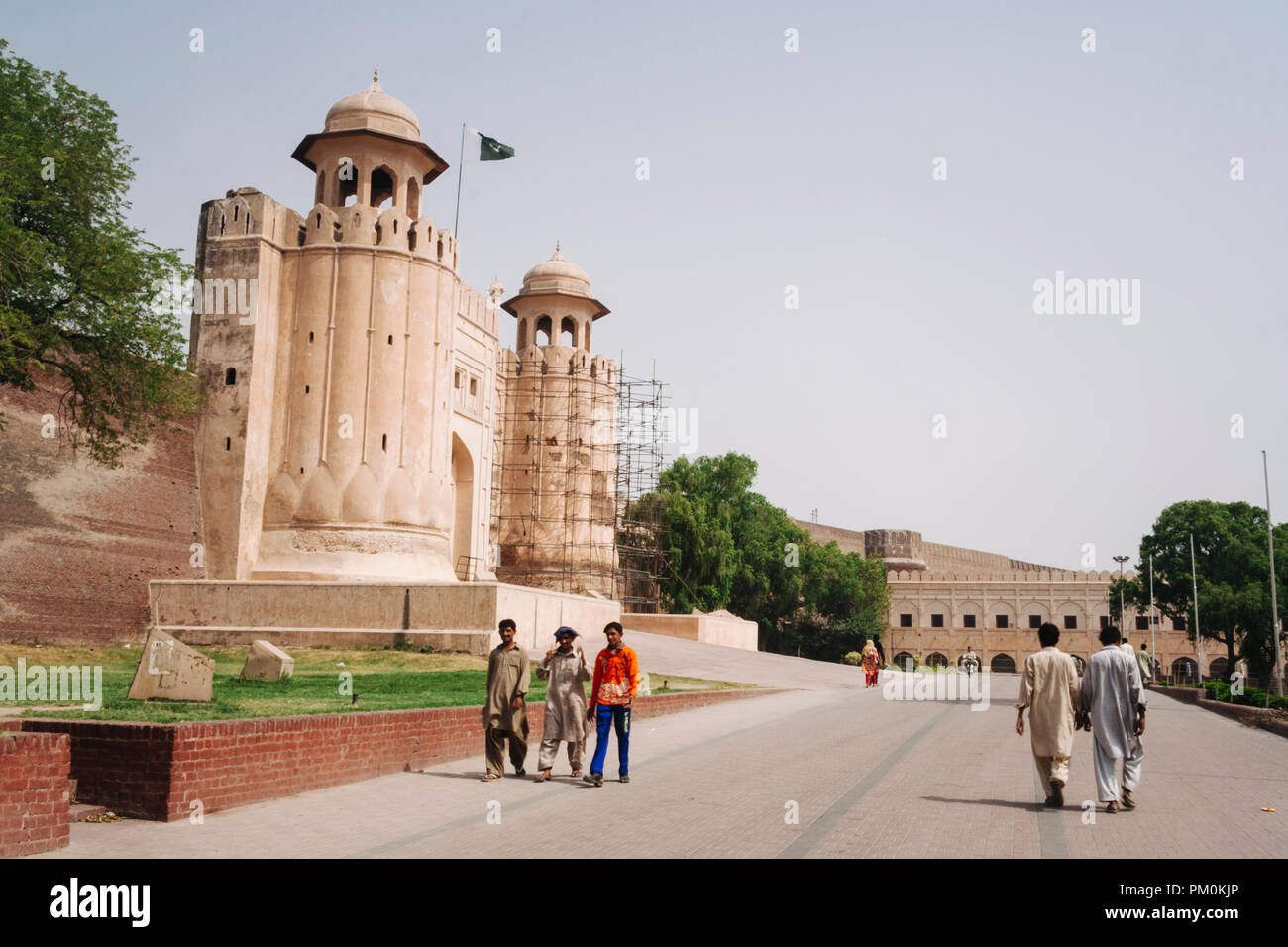 Lahore, Punjab, Pakistan, South Asia : People walk past the colossal Alamgiri Gate of the Shahi Qila or Lahore Fort, built in 1674 during the reign of Stock Photo