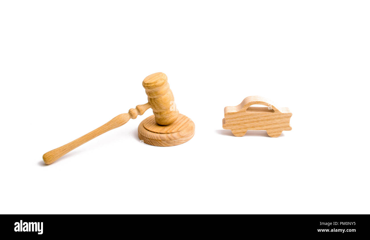 Wooden figurine of a car in the hammer of a judge on a white background. Minimalism. Purchase and sale of the car. The trial, confiscation of the mach Stock Photo