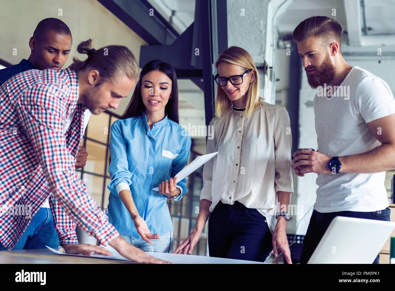 Successful team. Group of young business people working and communicating together in creative office. Stock Photo