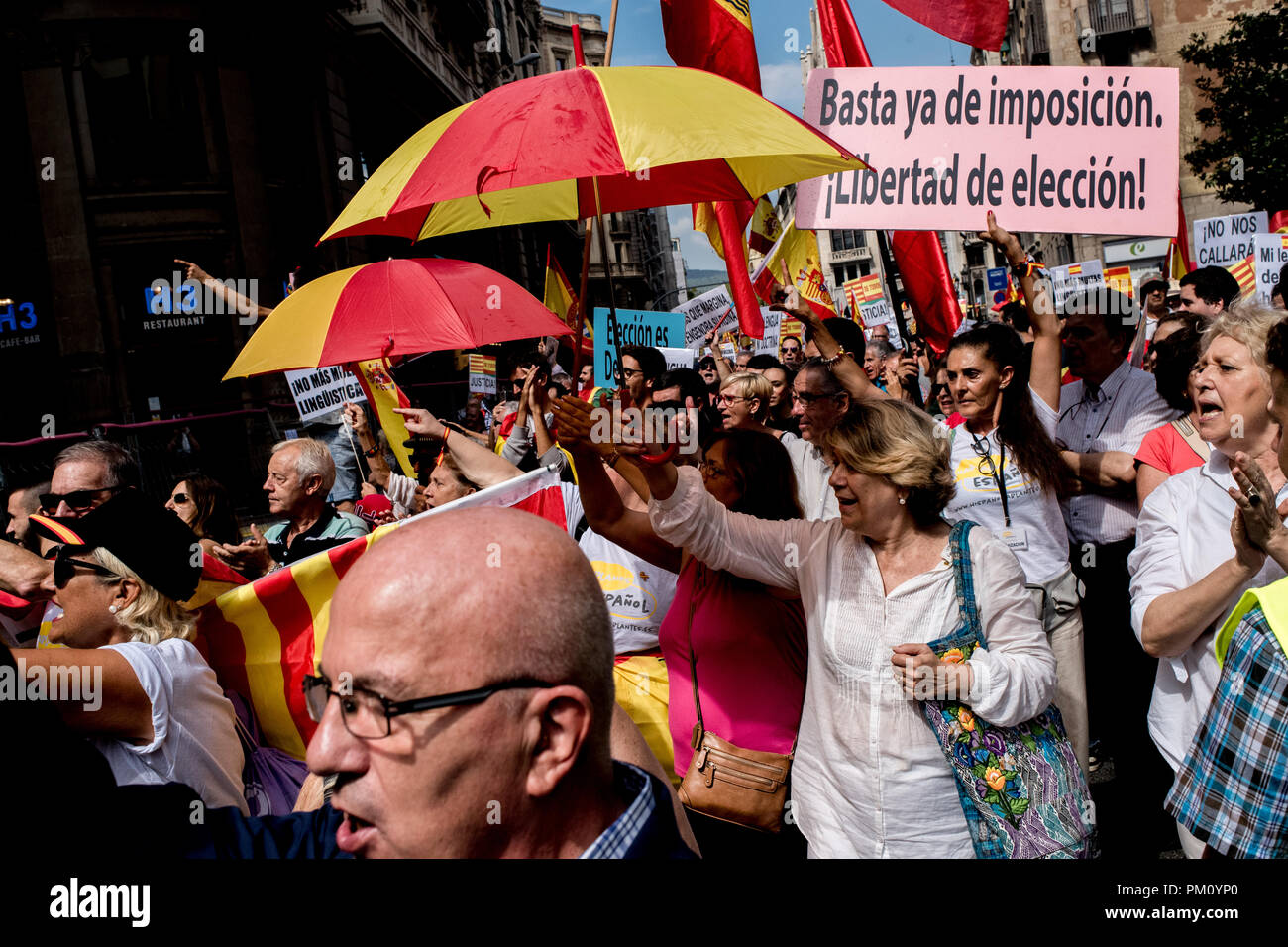 Barcelona, Spain. 16 September 2018.   Protesters called by unionist organizations hold Spanish  flags and colorful umbrellas in Barcelona. Demonstrators marched in support of the use of the Spanish language and against the Language immersion system, a technique using bilingual language education (Catalan and Spanish) in the Catalan schools. Credit:  Jordi Boixareu/Alamy Live News Stock Photo