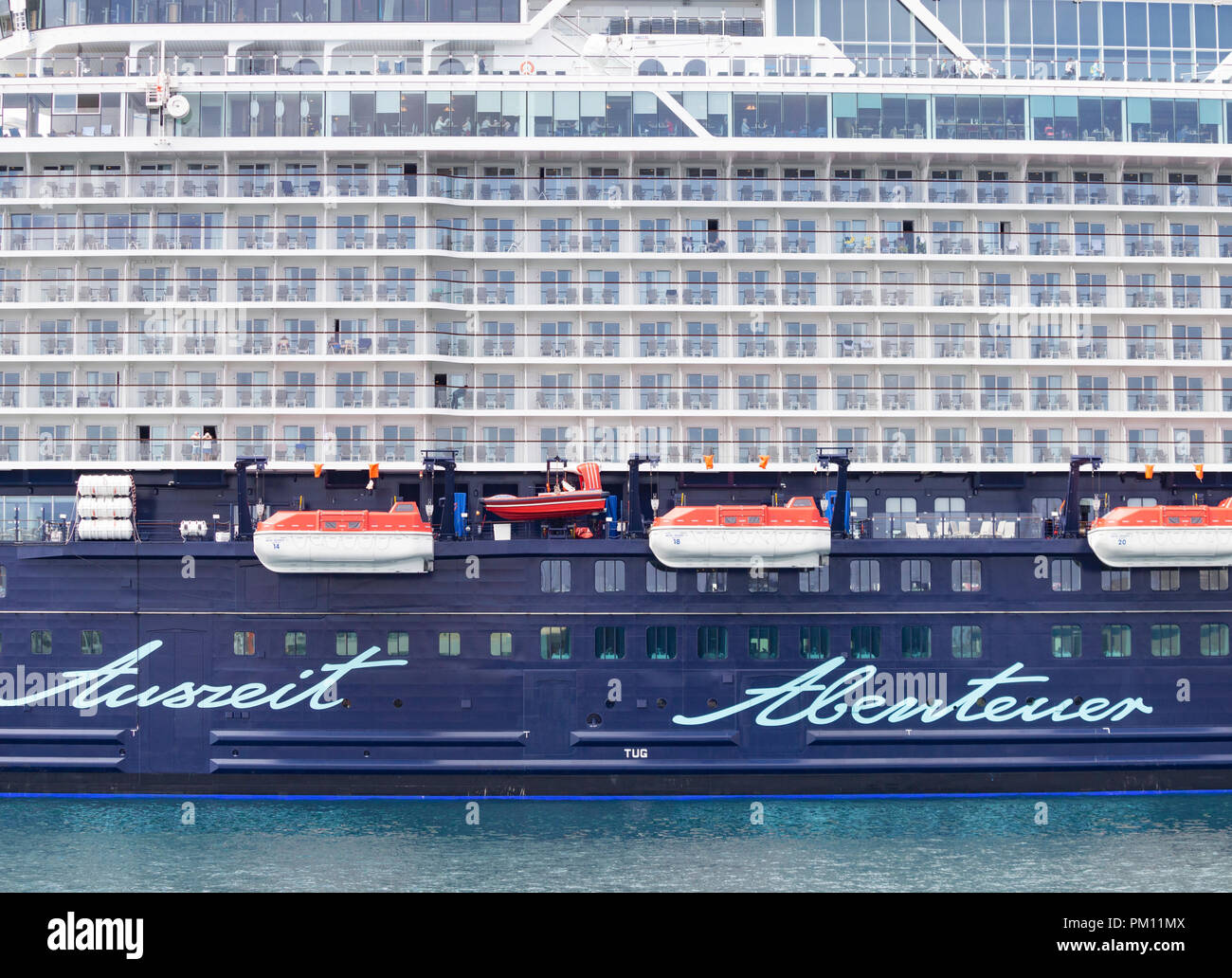 Las Palmas, Gran Canaria, Canary Islands, Spain. 16th September 2018. Mein Schiff 1, a new, high tech 315 metre long cruise ship in TUI cruises fleet, towers over ships and buildings in Las Palmas port as the ships starts its winter cruising season in The Canary Islands. The ship has a capacity for almost 3.000 passengers and is one of the first cruise ships equipped with catalytic converters for the main and auxiliary engines to reduce nitrogen oxide emissions. Credit: ALAN DAWSON/Alamy Live News Stock Photo