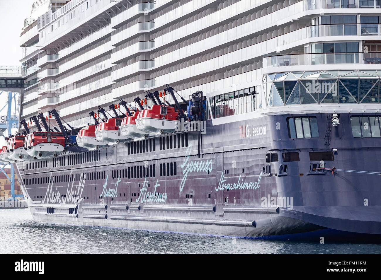 Las Palmas, Gran Canaria, Canary Islands, Spain. 16th September 2018. Mein Schiff 1, a new, high tech 315 metre long cruise ship in TUI cruises fleet, towers over ships and buildings in Las Palmas port as the ships starts its winter cruising season in The Canary Islands. The ship has a capacity for almost 3.000 passengers and is one of the first cruise ships equipped with catalytic converters for the main and auxiliary engines to reduce nitrogen oxide emissions. Credit: ALAN DAWSON/Alamy Live News Stock Photo