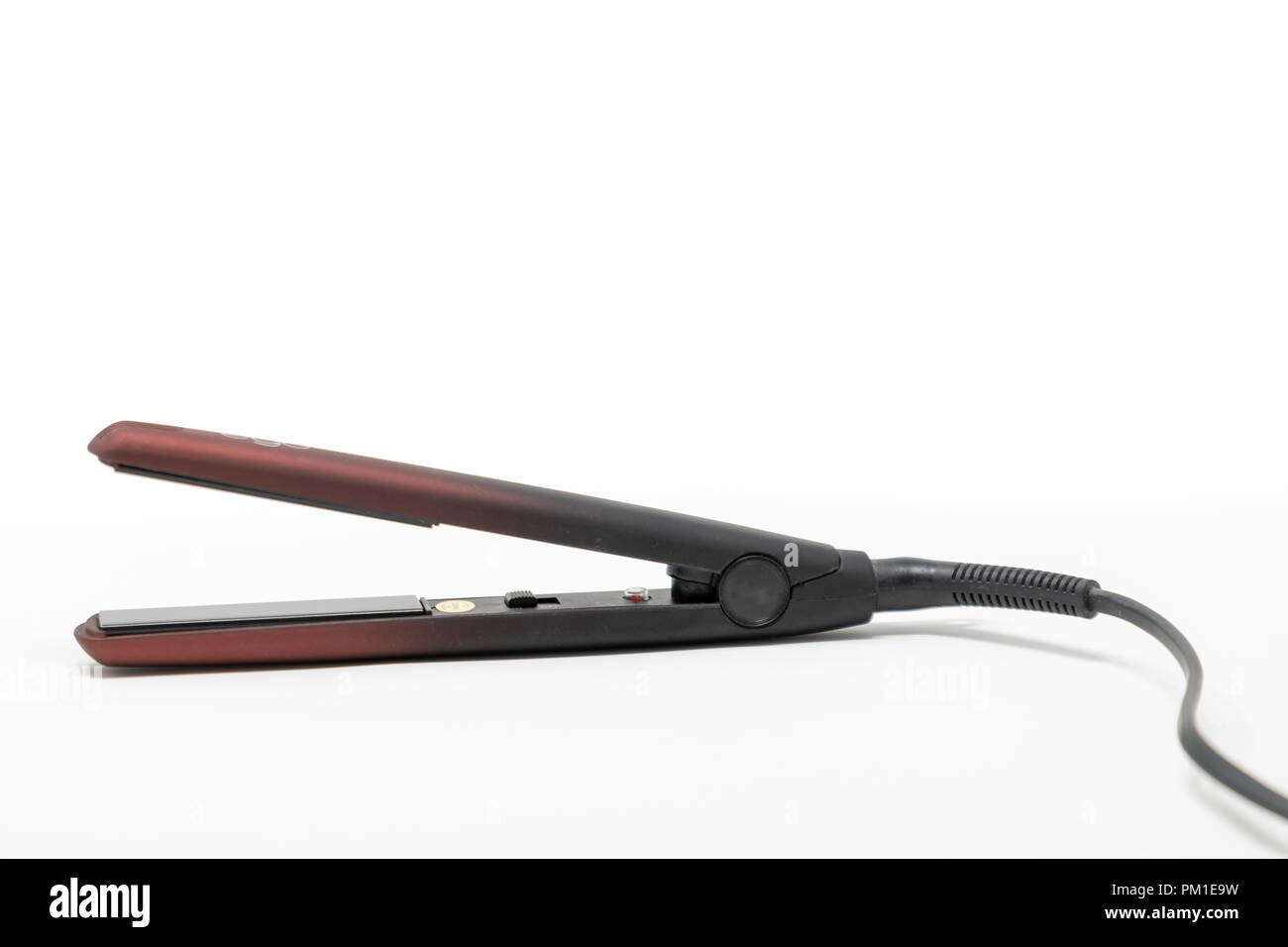 A debadged pair of hair straighteners set against a white background Stock Photo Alamy