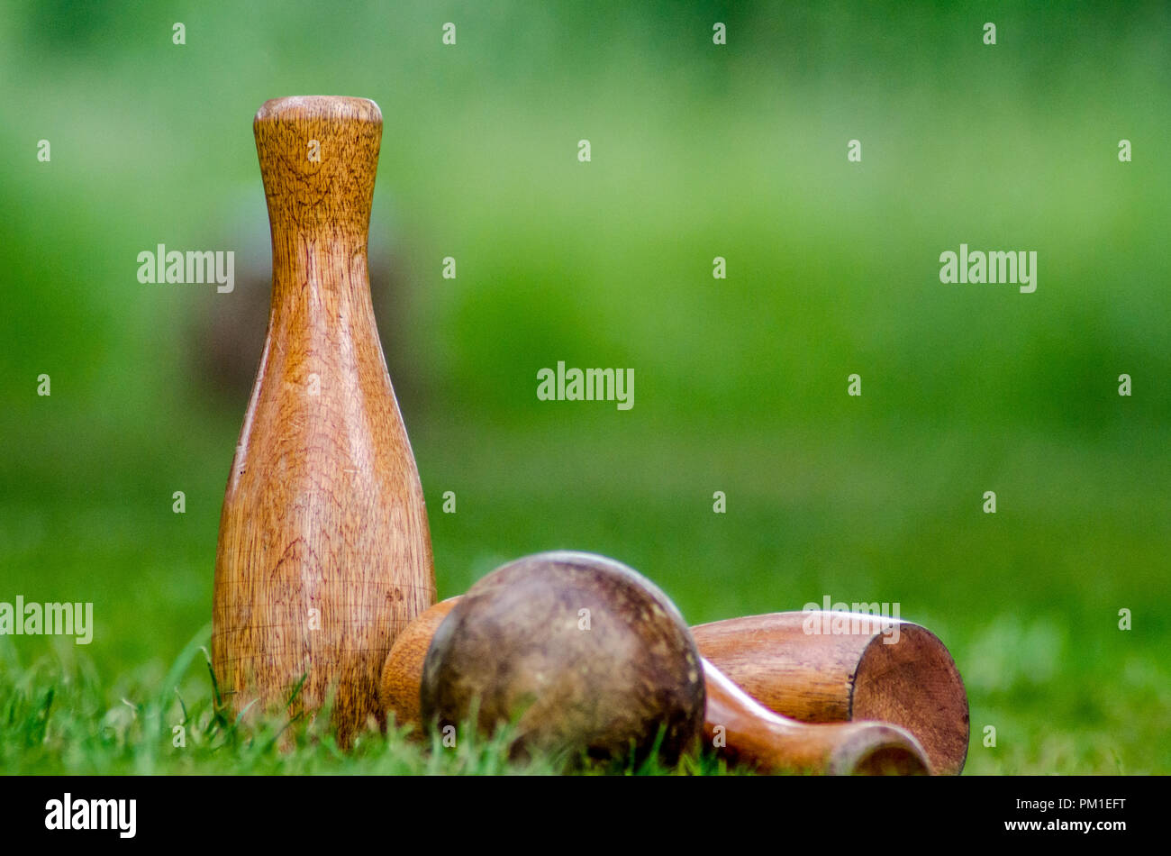 A wooden lawn skittles set on out of focus grass Stock Photo